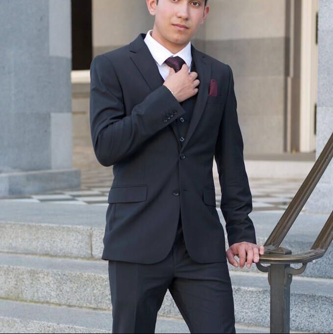 Man wearing a classic Charcoal Grey Two-Button Suit in 100% worsted Wool, illustrating essential first suit basics for men and the timeless foundation of formal and professional dressing.
