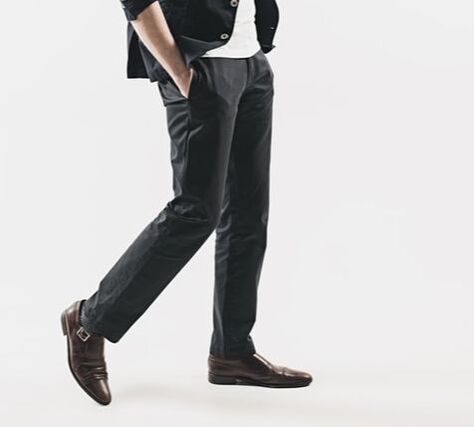Man wearing tailored dress trousers styled for formal and business occasions, showcasing classic wool trousers in a refined fit, suitable for pairing with a dress shirt, blazer, and leather shoes in professional menswear.