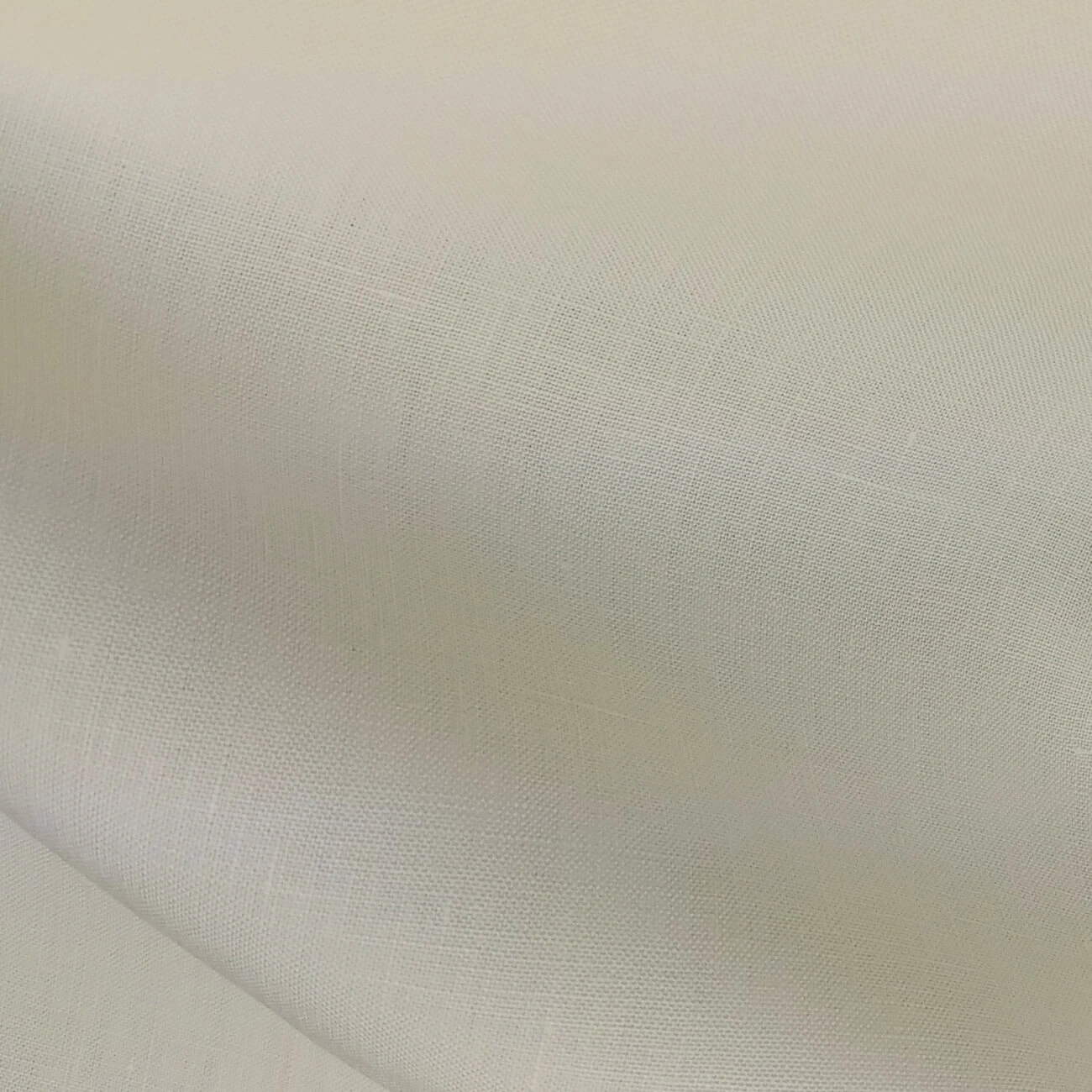 Ivory Baird McNutt mercerized linen suiting fabric, fully shrunk, close-up showing fine weave texture and soft natural drape, premium breathable linen for luxury summer suits, tailored jackets, and elegant warm-weather menswear.
