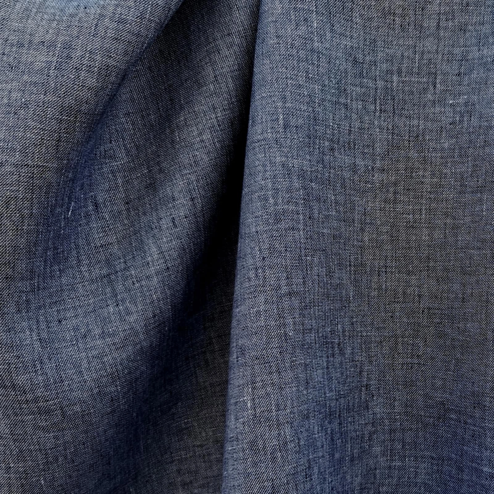 Denim blue linen suiting fabric close-up showing diagonal weave texture, crisp structure, and soft hand feel, premium breathable linen ideal for summer suits, tailored jackets, business casual and refined menswear styling.