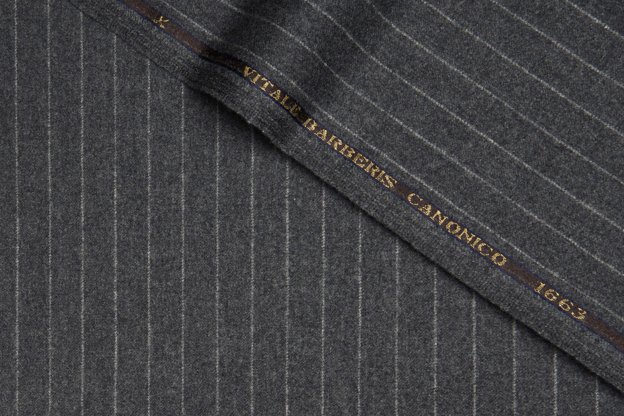VBC light grey flannel striped wool suiting fabric close-up, 340g brushed wool with soft texture and fine pinstripes, premium Italian fabric for winter suits, business tailoring, and bespoke formal menswear