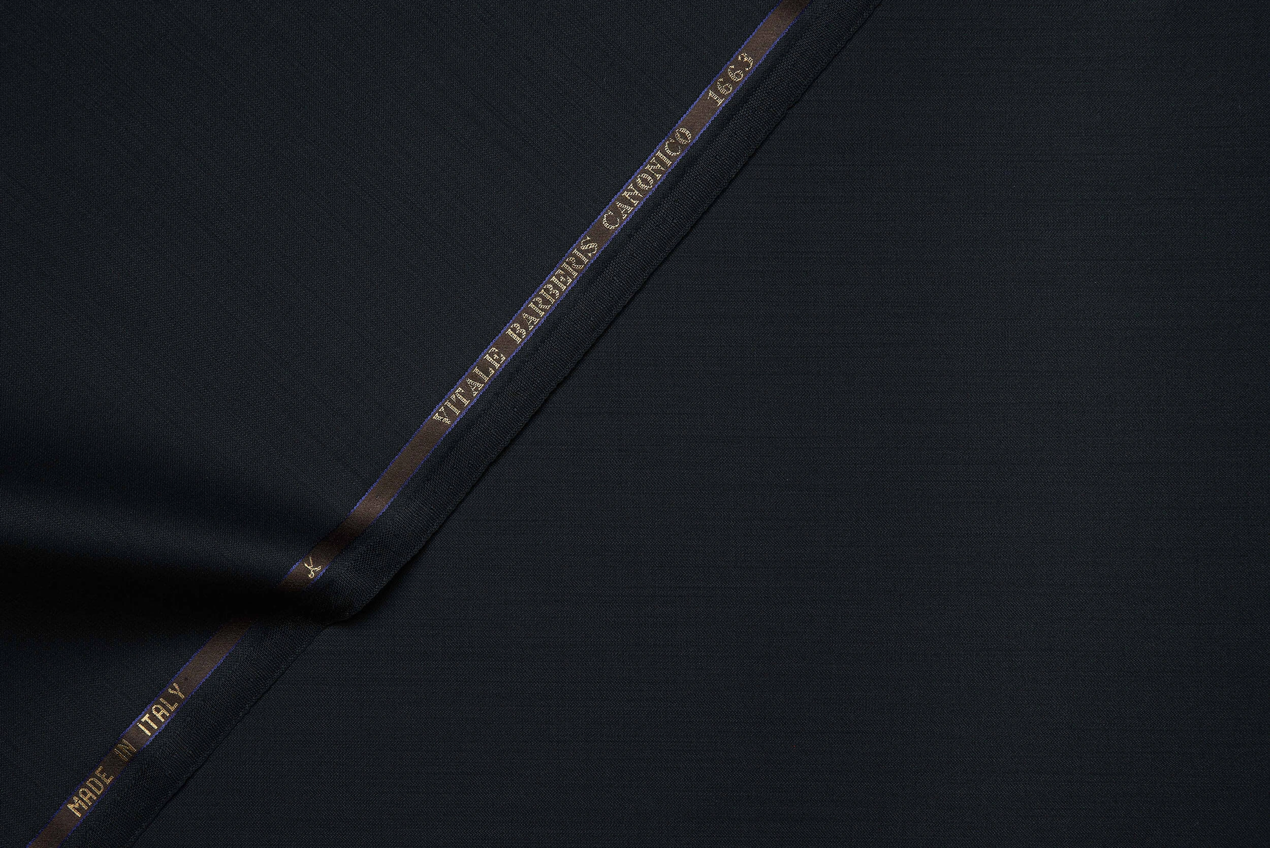 VBC dark blue plain weave wool suiting fabric close-up, 300g ceremonial weight with smooth surface and structured drape, luxury Italian wool ideal for formal suits, evening wear, and bespoke tailoring craftsmanship